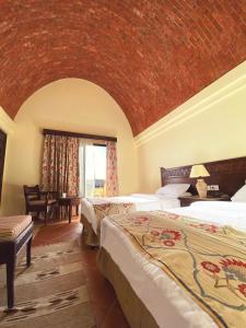 a bedroom with two beds and a brick wall at ONATTI Beach Resort - Adults Only 16 Years Plus in Quseir