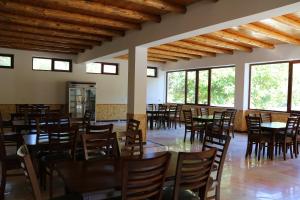 uma sala de jantar com mesas, cadeiras e janelas em Sayyod Yurt Camp em Sayyod