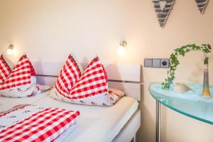 a room with two beds with red and white pillows at Ferienwohnung Obstwiese in Hergensweiler
