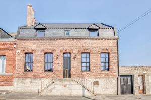 un ancien bâtiment en briques avec un escalier devant lui dans l'établissement Gîte des Ducs de Guise, à Guise