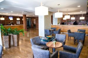 a restaurant with chairs and tables and a bar at Hotel Ring in Orechová Potôň