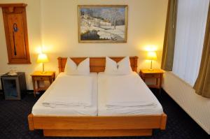 a bedroom with two beds and two lamps at Fürstenhof Wernigerode Garni in Wernigerode