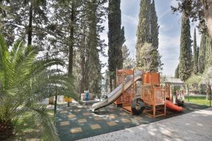 a playground with a slide in a park with trees at Garden Resort in Gagra