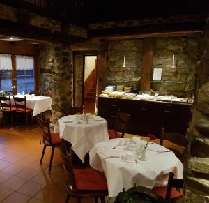 ヴェルニゲローデにあるFürstenhof Wernigerode Garniの白いテーブルクロスのテーブル2台付きレストラン