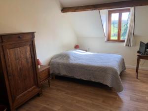 a bedroom with a bed and a dresser and a window at Chambres d'hôtes Domaine De La Jonquière, Bouloire in Bouloire