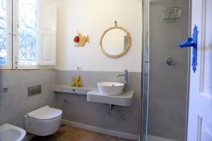 y baño con lavabo, aseo y espejo. en Villa delle terrazze, en Punta Secca