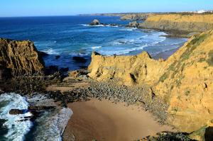 an aerial view of a beach with rocks and the ocean at Casa do Viajante - Family in Zambujeira do Mar +14 photos