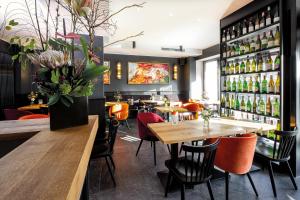 un restaurant avec des tables, des chaises et une étagère de bouteilles dans l'établissement Prevôt Restaurant & Hotel, à Cologne