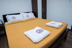 a bed with white towels on top of it at Hotel Mookambika Comforts in Tirupati