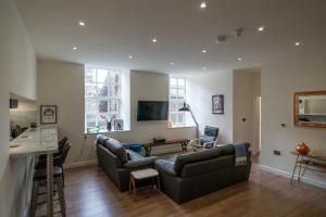 a living room with two couches and a kitchen at 23 Tanners Yard in Kendal
