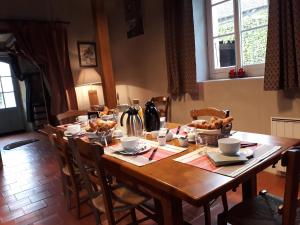 a wooden table with bowls of food on it at Au Château Juillac in Juillac