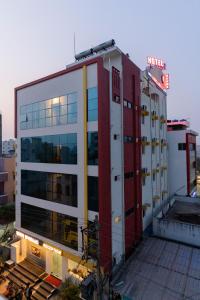 ein großes Gebäude in Rot und Weiß in der Unterkunft Hotel Mookambika Comforts in Tirupati