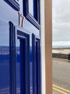 a blue building with a reflection in the window at Breakwater in North Berwick