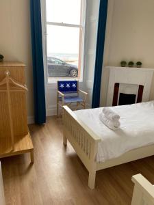 a bedroom with a bed and a fireplace and a window at Breakwater in North Berwick