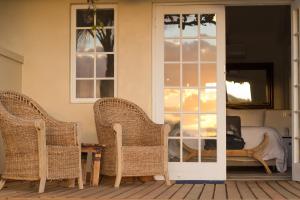 a room with two wicker chairs and a bed at theLAB Robertson in Robertson