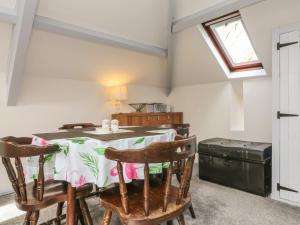 a dining room with a table and chairs and a window at The Loft in Holsworthy +6 photos