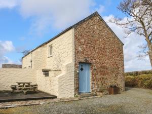 a brick barn with a picnic table and a picnic table at The Loft in Holsworthy