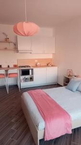 a bedroom with a large bed and a kitchen at DIMENTICA IL CERVELLO in Palermo