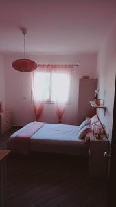 sypialnia z łóżkiem i oknem z zasłonami w obiekcie DIMENTICA IL CERVELLO w mieście Palermo