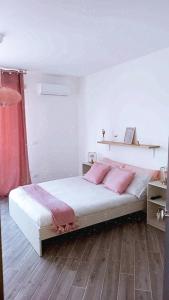sypialnia z łóżkiem z różowymi poduszkami w obiekcie DIMENTICA IL CERVELLO w mieście Palermo
