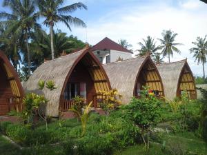 a group of cottages with thatched roofs at Kelapa Gading Bungalows in Gili Islands