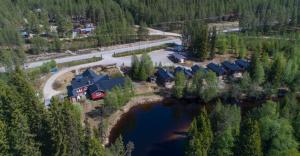 an aerial view of a house next to a lake at Vålkojan Naturby - Timber cottages with river view in Vemdalen