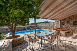 a patio with a table and chairs next to a pool at Villa Elia in Dhrámia