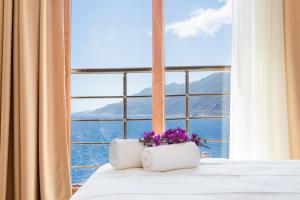 a bedroom with a large window with flowers on the bed at Medimar Hotel in Kaş