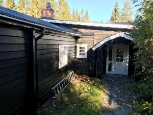 an entrance to a house with a door at Vålkojan Naturby - Timber cottages with river view in Vemdalen