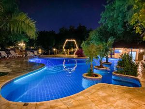 a swimming pool at night with blue lights at Los Lagos Resort Hotel in Capiatá