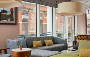 a living room with a couch and some windows at Citadines Islington London in London