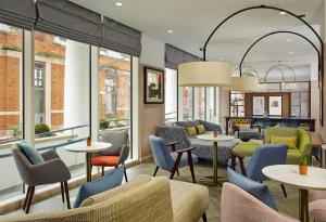a restaurant with tables and chairs and windows at Citadines Islington London in London