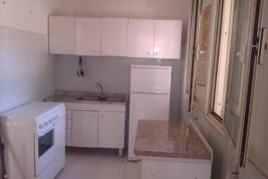 uma pequena cozinha com armários brancos e um frigorífico branco em Villa Rustica em Nardò