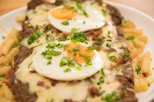 a plate of food with eggs and french fries at Los Lagos Resort Hotel in Capiatá