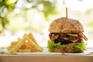 a chicken sandwich and french fries on a plate at Los Lagos Resort Hotel in Capiatá