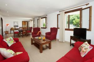 ein Wohnzimmer mit roten Sofas und einem TV in der Unterkunft Villa La Rovina in Alcúdia