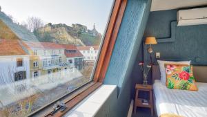 a bedroom with a large window with a mountain view at Bed and Breakfast De Heren van Valkenburg in Valkenburg