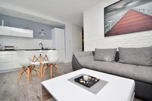 a living room with a couch and a table at APARTAMENT - DZIWNÓWEK - LEŚNE TARASY - 45B/10 - 150 M OD MORZA in Dziwnówek