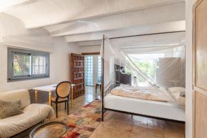 a bedroom with a bed and a couch and a table at Pool House in Palma de Mallorca