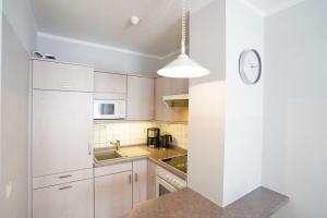 a kitchen with white cabinets and a clock on the wall at Ferienwohnung Garzmann in Bad Reichenhall