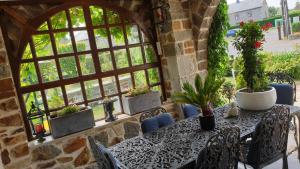 a table and chairs in a room with windows at Le Prangeleux in Tenneville