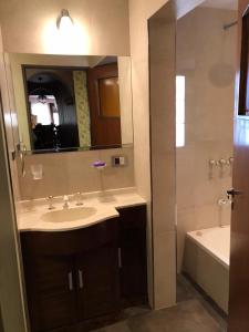 a bathroom with a sink and a tub and a mirror at SWEET HOME PATAGONIA in Comodoro Rivadavia