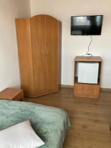 1 dormitorio con 1 cama, TV y armario en Willa Perełka, en Mielno