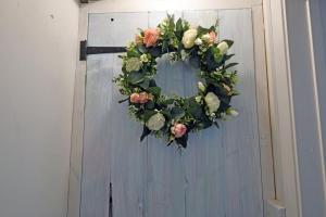 a wreath on a door with flowers on it at Charming 1-Bed cottage in Pembroke close to castle in Pembroke