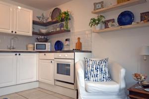 a kitchen with a couch and a chair in a room at Charming 1-Bed cottage in Pembroke close to castle in Pembroke