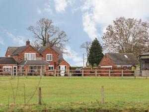 a large house with a field in front of it at Wagtail in Tarporley