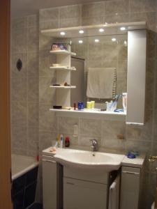 Un baño con lavabo, espejo y bañera. en Ferienwohnung Garzmann, en Berchtesgaden