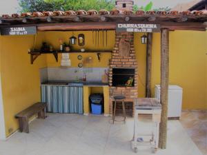 an outdoor kitchen with a table and a bench at Pousada das Bromélias in Serra do Cipo