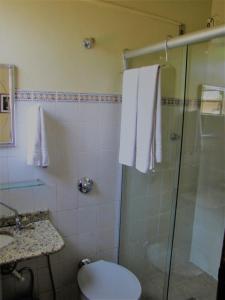 y baño con ducha, aseo y lavamanos. en Pousada das Bromélias, en Serra do Cipo