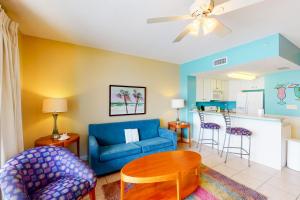 sala de estar con sofá azul y mesa en Seychelles Beach Resort III en Panama City Beach